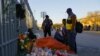 Migrants speak next to an altar outside the migrant detention center where several migrants died after a fire broke out late on Monday, in Ciudad Juarez, Mexico, March 29, 2023.