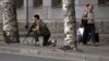 A Donetsk People's Republic fighter stands guard near a shopping mall damaged by an explosion in the city of Donetsk, eastern Ukraine, July 11, 2014.