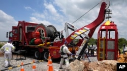 Para anggota tim evakuasi mengangkat kurungan yang digunakan untuk menyelamatkan penambang yang terperangkap di sebuah tambang emas yang telah ditinggalkan di Stilfontein, Afrika Selatan, pada 16 Januari 2025. (Foto: AP/Themba Hadebe)