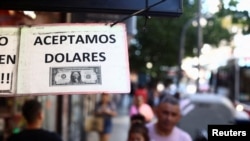 Un cartel afuera de una tienda anuncia en español "Aceptamos dólares", en Buenos Aires, Argentina, el 12 de diciembre de 2023.