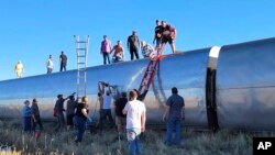 Orang-orang bekerja di lokasi kereta Amtrak tergelincir 25 September 2021, di utara-tengah Montana.(Foto: AP)