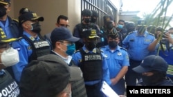 Mantan Presiden Honduras Juan Orlando Hernandez mendengarkan seorang petugas polisi setelah ditahan oleh anggota Kepolisian Nasional Honduras, di Tegucigalpa, Honduras, 15 Februari 2022. (Foto: via Reuters)