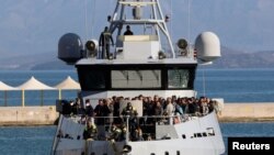 Penumpang yang diselamatkan dari Euroferry Olympia berbendera Italia, yang terbakar di Pulau Corfu, terlihat di atas kapal Guardia di Finanza di pelabuhan, Yunani, 18 Februari 2022. (REUTERS/Giorgos Korkidis)