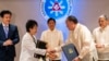 Japan's Foreign Minister Yoko Kamikawa and Philippine Defense Minister Gilberto Teodoro shake hands after signing the Reciprocal Access Agreement at the Malacanang Palace in Manila on July 8, 2024.