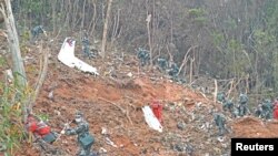 Para petugas mencari kotak hitam di lokasi jatuhnya pesawat China Eastern Airlines di Wuzhou, Guangxi, China, pada 22 Maret 2022. (Foto: Xinhua via Reuters/Zhou Hua)