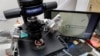 FILE - Lab staff use a microscope and articulated hand controls to extract cells from 1- to 7-day-old embryos, shown on the monitor at right, that are then checked for viability at the Aspire Houston Fertility Institute in vitro fertilization lab, Feb. 27, 2024, in Houston.