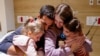 TOPSHOT - An image distributed by the Schneider Children Medical Centre shows Yoni Asher being reunited with his children Aviv, 2.5 years old, her sister Raz, 4.5 years old, and his wife Doron, on November 25, a day after they were released by Hamas in a 
