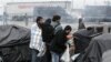 Migrants try to salvage belongings as French authorities clear out makeshift camps housing hundreds of illegal migrants from the Middle East, Asia and Africa in the English Channel port city of Calais, northern France, May 28, 2014.