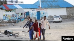 በጥቃቱ የተገደለችውን ሴት አስከሬን ዘመዶች ተሸክመው ይታያል፣ ሐምሌ 27 ቀን 2016 ዓ.ም. (Photo by Hassan Ali ELMI / AFP)
