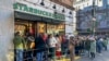 Una fila de personas espera en una cafetería Starbucks en Nueva York el 23 de noviembre de 2023.