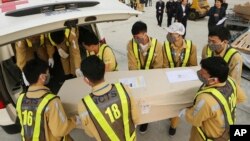 Petugas bandara memasukkan peti jenazah ke ambulans di bandara Noi Bai di Hanoi, Vietnam. Jenazah 16 dari 39 migran Vietnam yang ditemukan tewas di sebuah truk di Inggris dipulangkan ke Vietnam (foto: dok). 