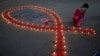 Seorang perempuan tampak menyalakan lilin dalam peringatan Hari AIDS sedunia di Kolkata, India, pada 1 Desember 2021. (Foto: Reuters/Rupak De Chowdhuri)
